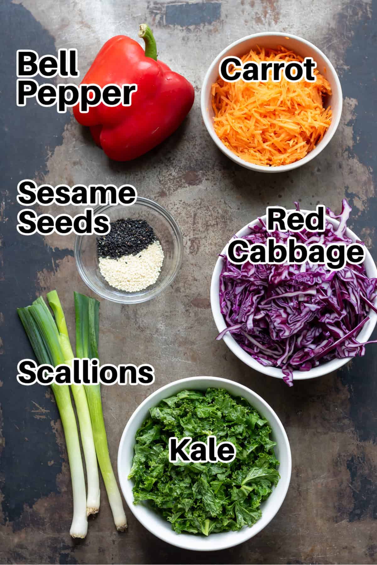 Ingredients on a table, including red bell peppers, carrots and cabbage.