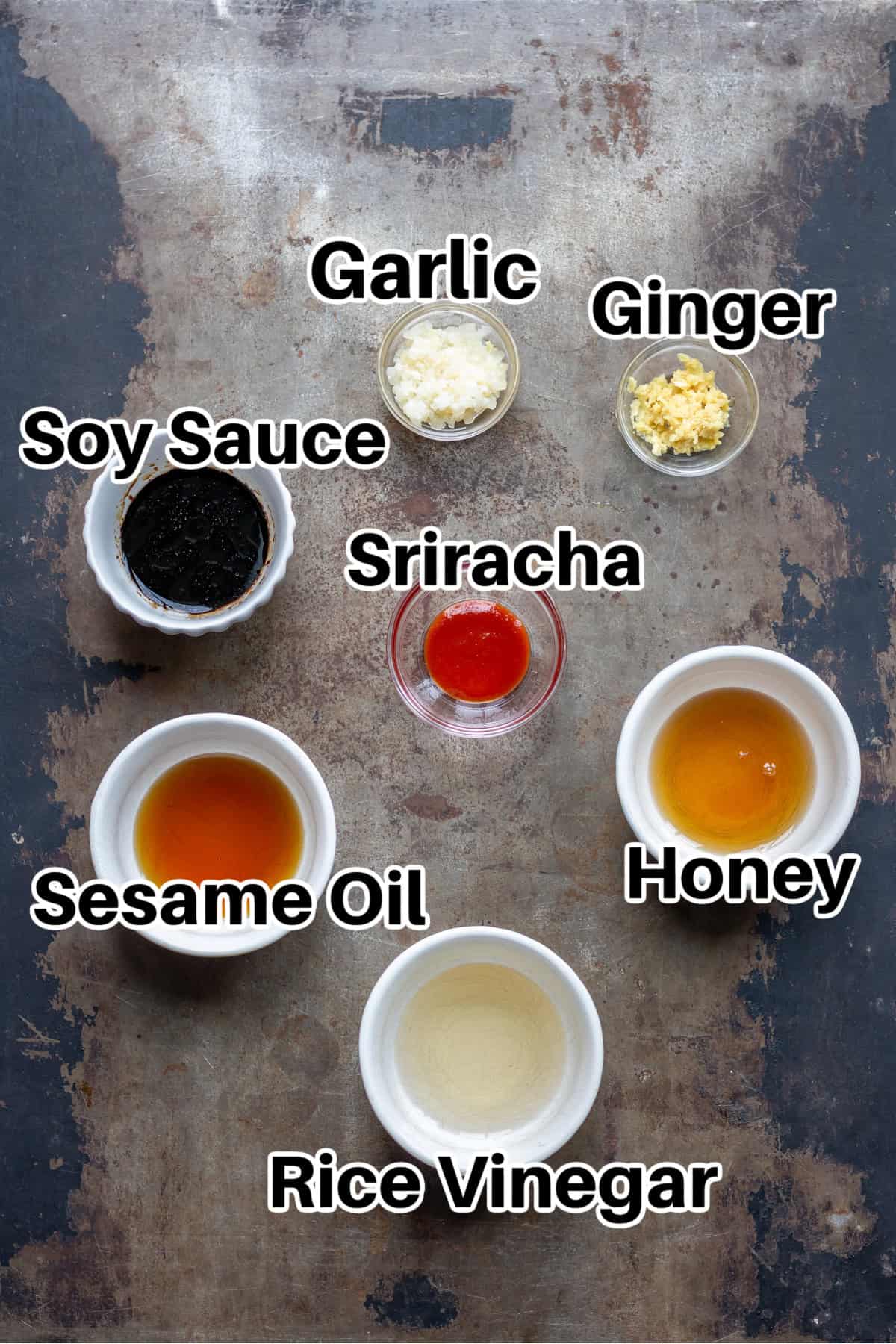 Asian dressing ingredients on a table, including garlic, ginger, soy sauce and honey.
