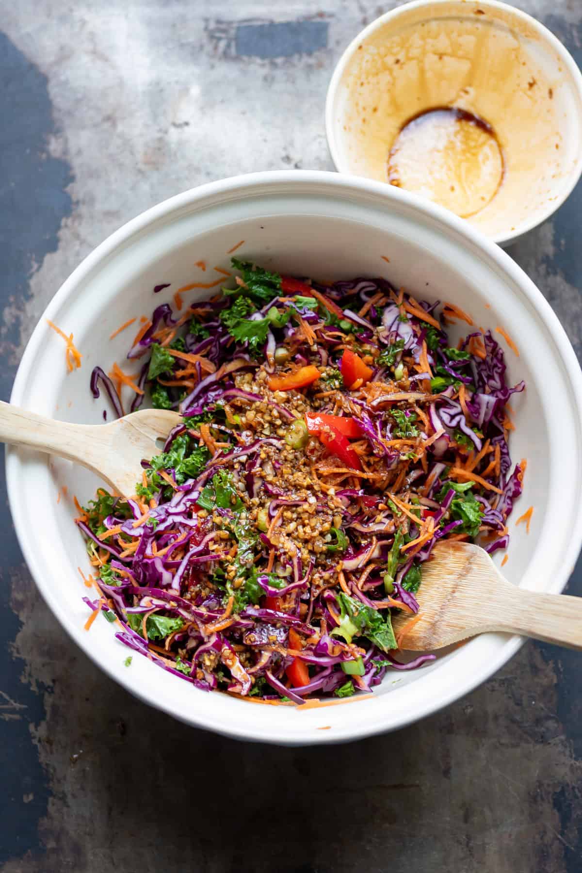 Mixing the asian dressing into the coleslaw vegetables.