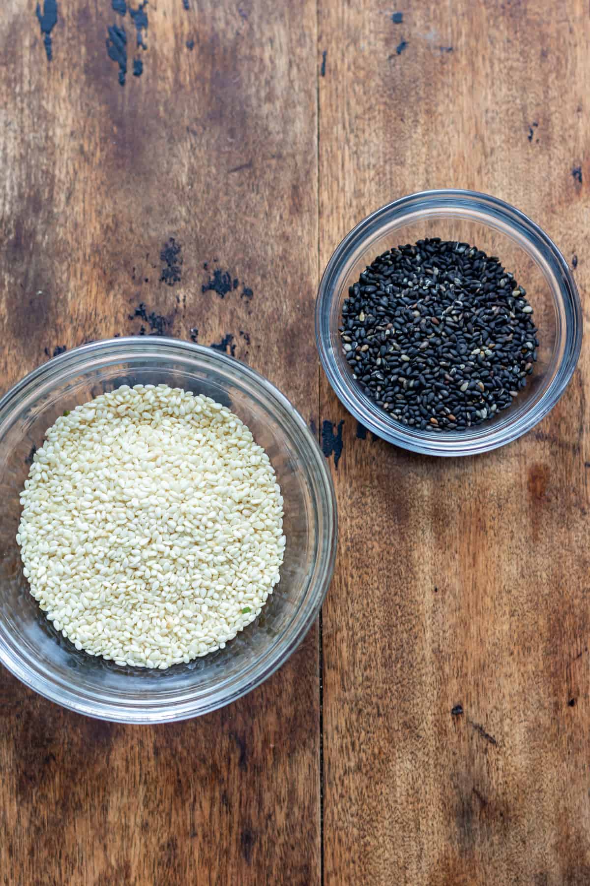 Dishes of black and white sesame seeds.