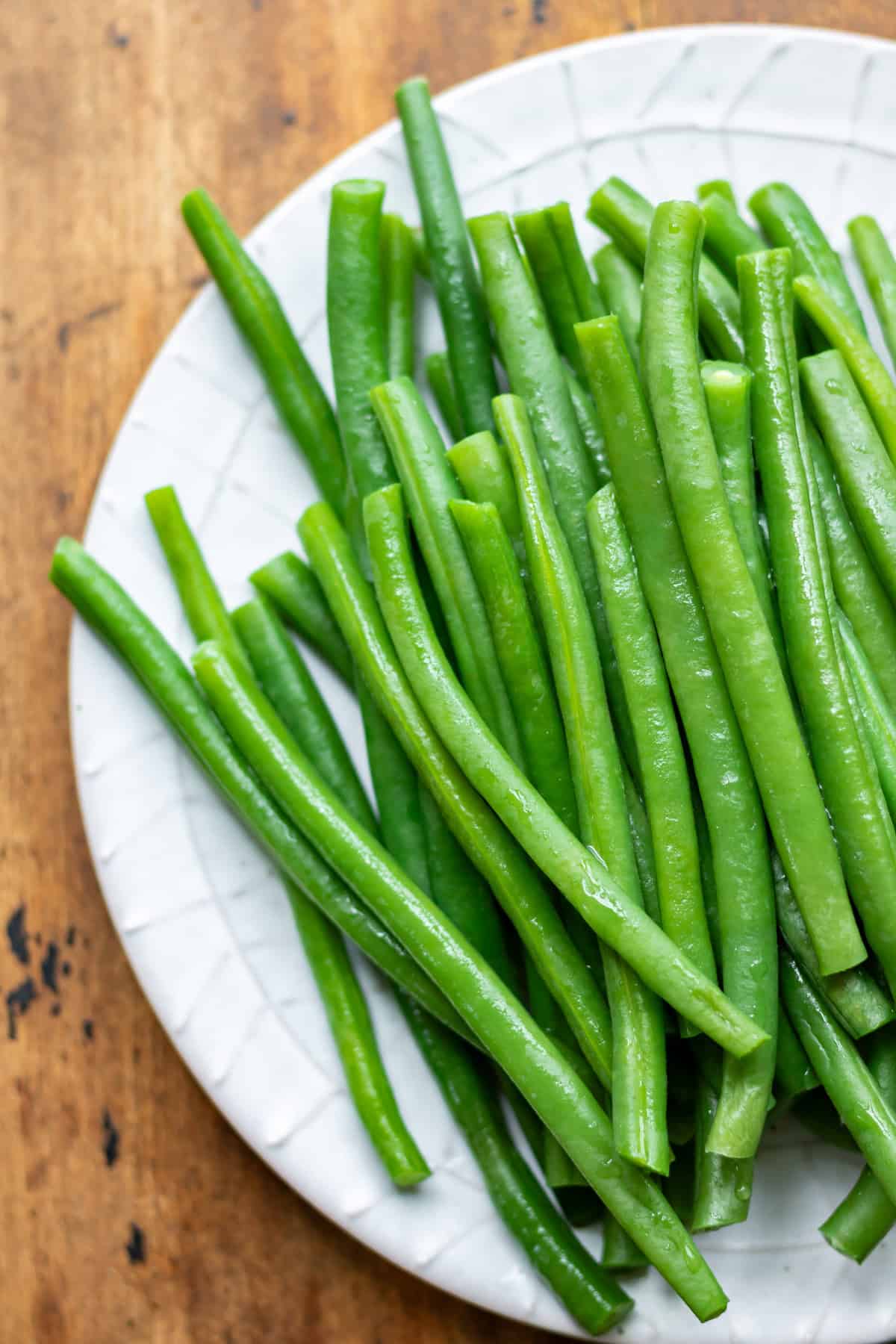 Close up of a pile of blanched green beans on a plate.