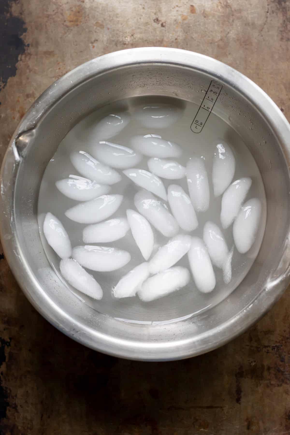 An ice bath - bowl of water with ice in it.